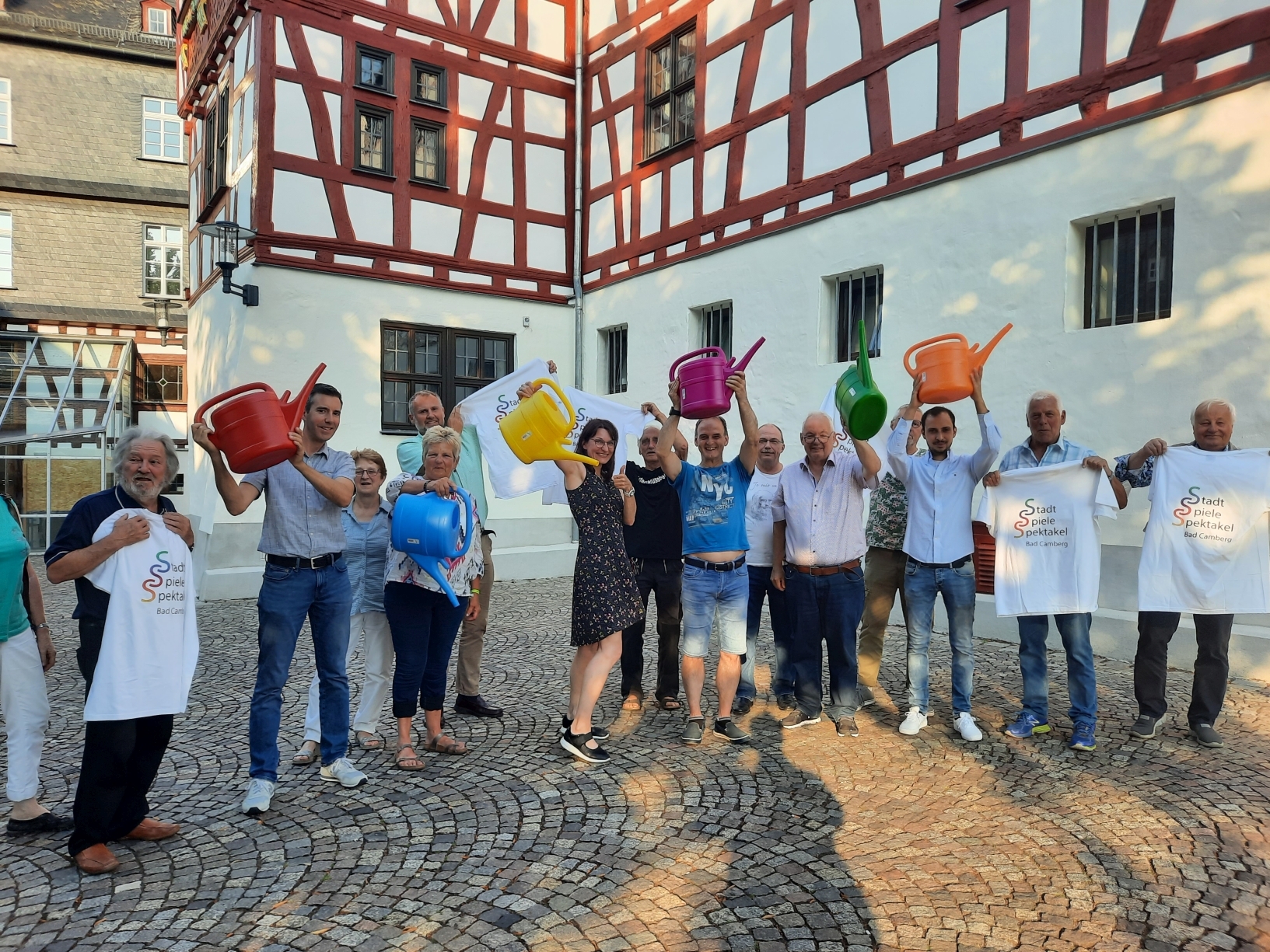 städtisches Planungsteam und die Ortsvorsteher mit den Gießkannen in der Farbe, in denen die Teams der Stadtteile am 27. August gegeneinander antreten werden.