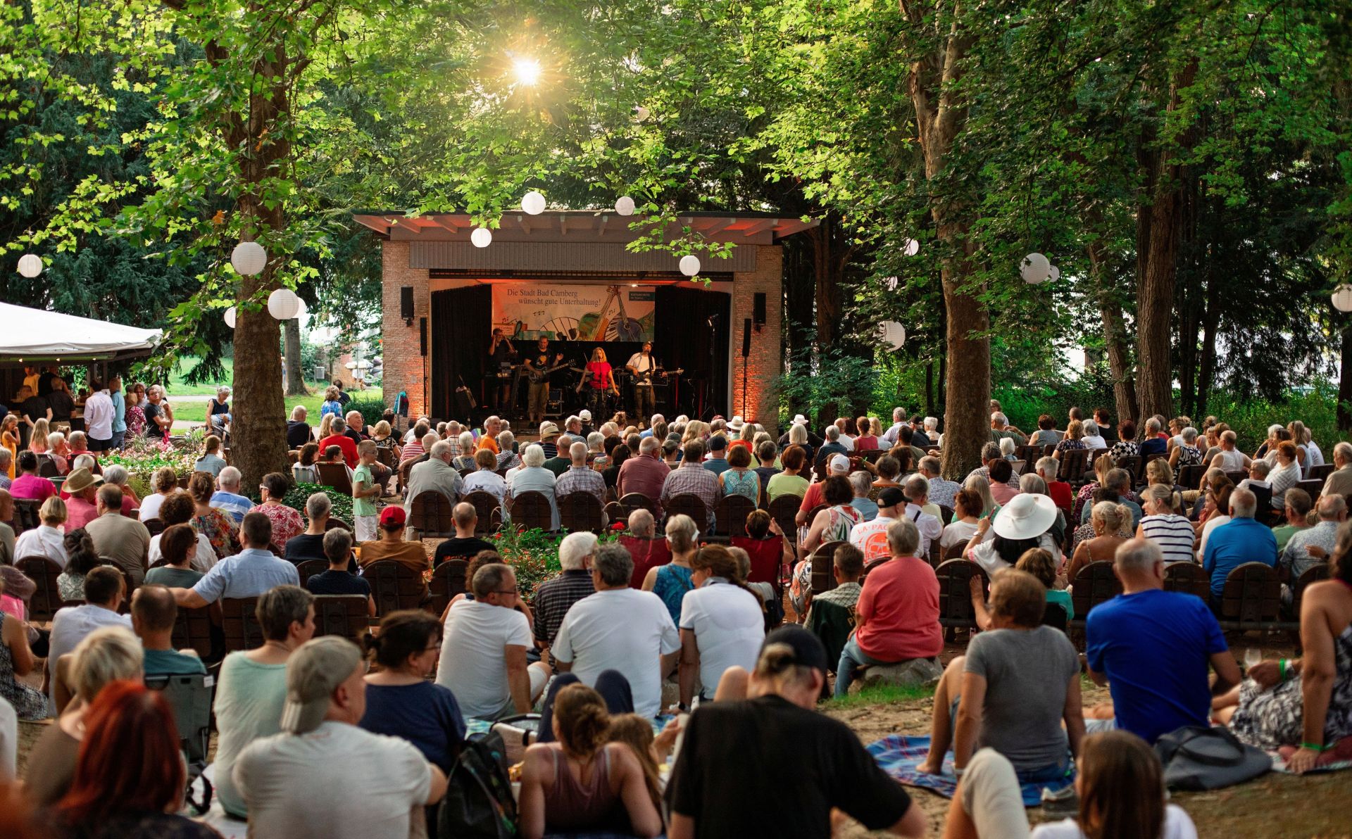 Zu sehen ist: Zahlreiche Gäste vor dem Musikpavillon im Kurpark