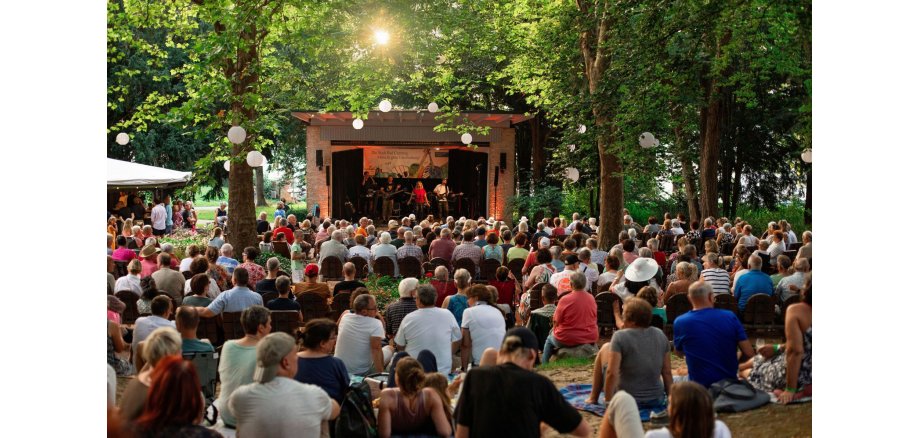 Zu sehen ist: Zahlreiche Gäste vor dem Musikpavillon im Kurpark