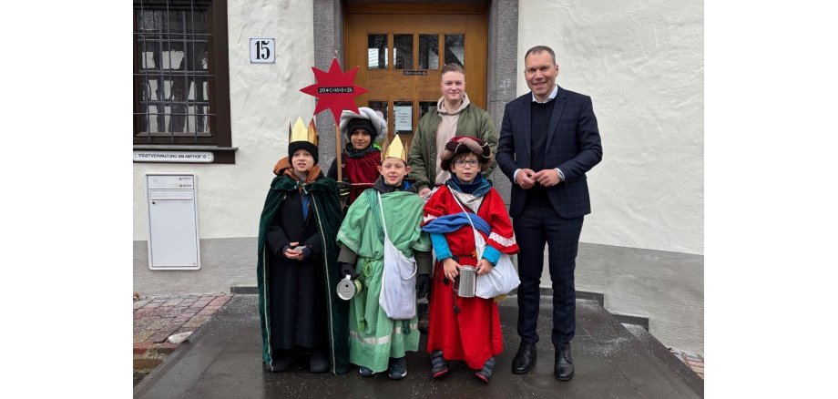 Zu sehen ist: Bürgermeister Daniel Rühl empfängt die Sternsinger vor der Tür des Amthofs