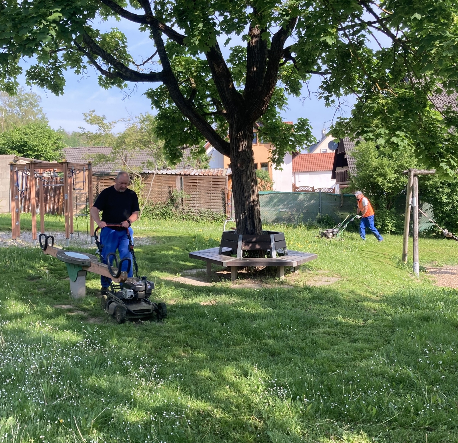 Bauhofmitarbeiter mähen Spielplatz