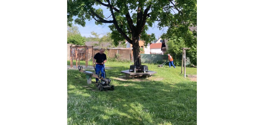 Bauhofmitarbeiter mähen Spielplatz