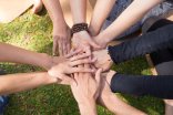 Top view of stack of hands against green grass Top view of stack of hands against green grass